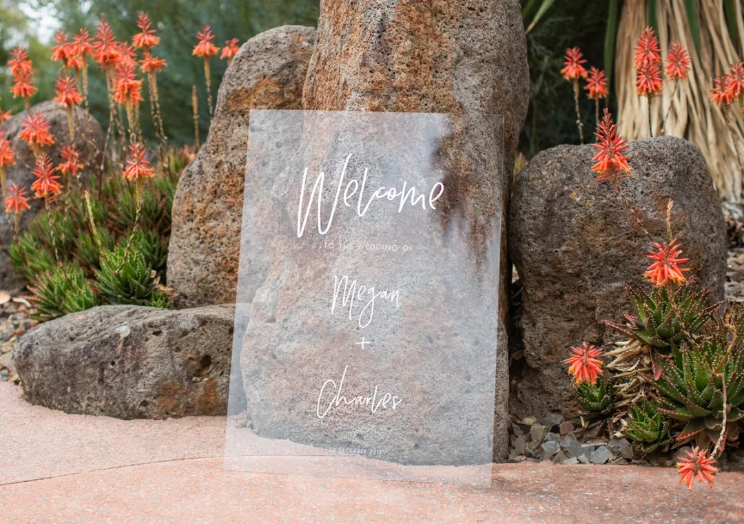 Clear acrylic wedding welcome sign among succulents: an elegant alternative to fabric signs