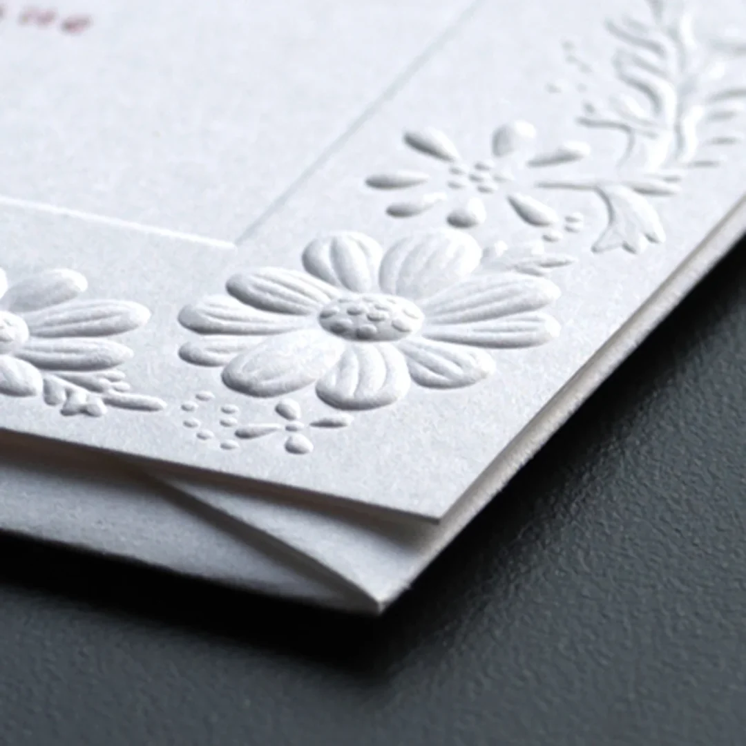 Blind embossed floral wedding stationery showing raised dimensional relief texture on white card stock