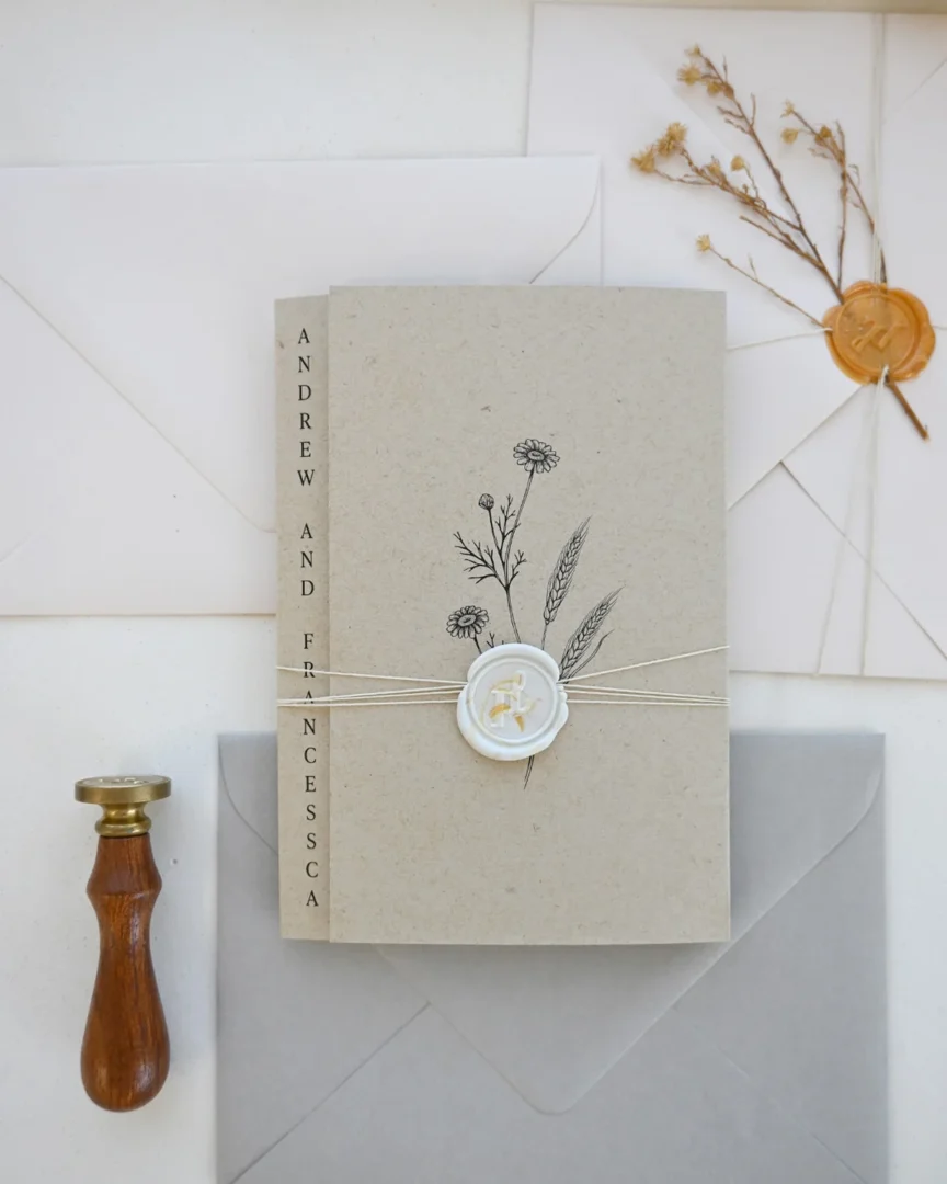 Botanical kraft wedding program booklet with wax seal held at ceremony