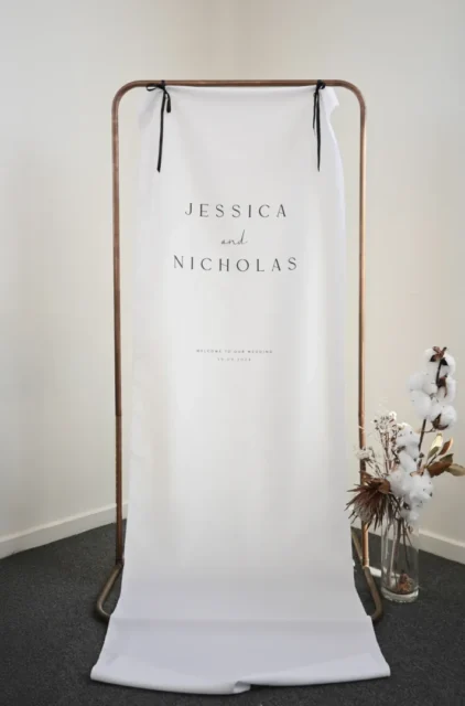 Byron fabric wedding welcome sign hung on a copper stand with dried florals: Paperlust fabric wedding signs