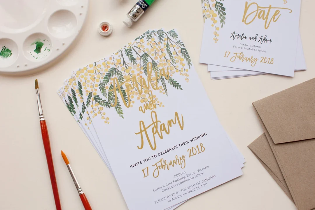 Wedding invitation with gold metallic ink lettering styled with paintbrushes and watercolor palette