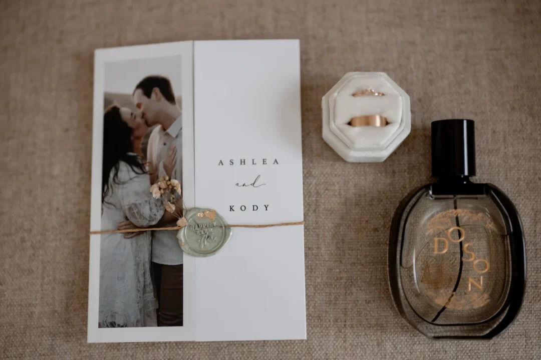 open boxed wedding invitation showing layered suite contents - invitation, vellum wrap, dried botanicals arranged inside wedding stationery