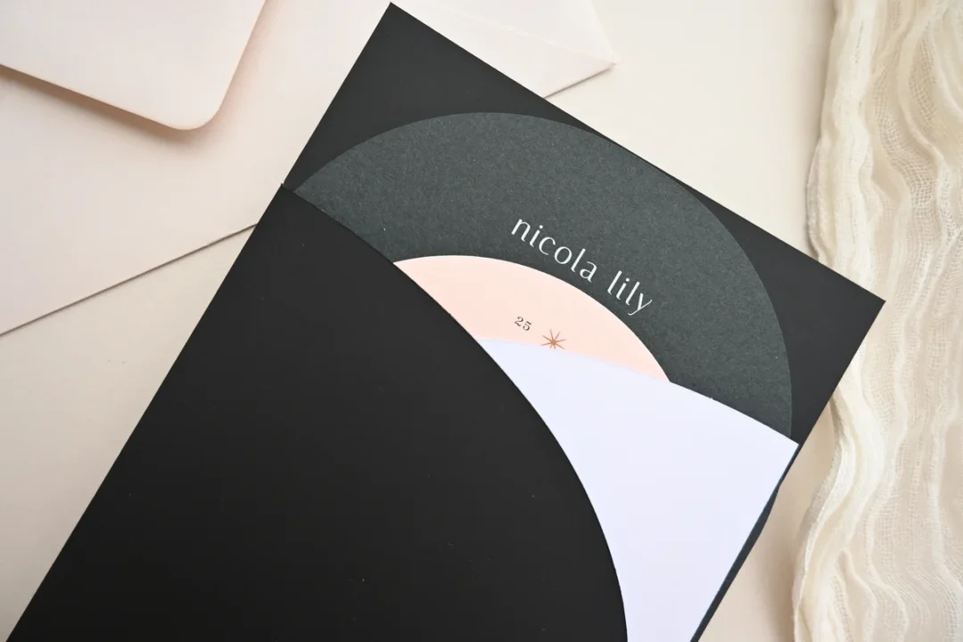 Open pocket wedding invitation showing layered insert cards with RSVP and details card