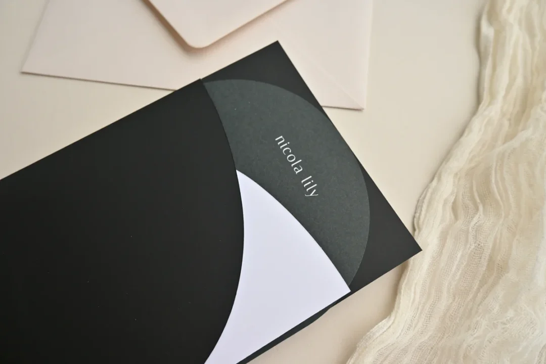 pocket wedding invitation opened showing layered insert cards fanned against colored pocket interior wedding stationery