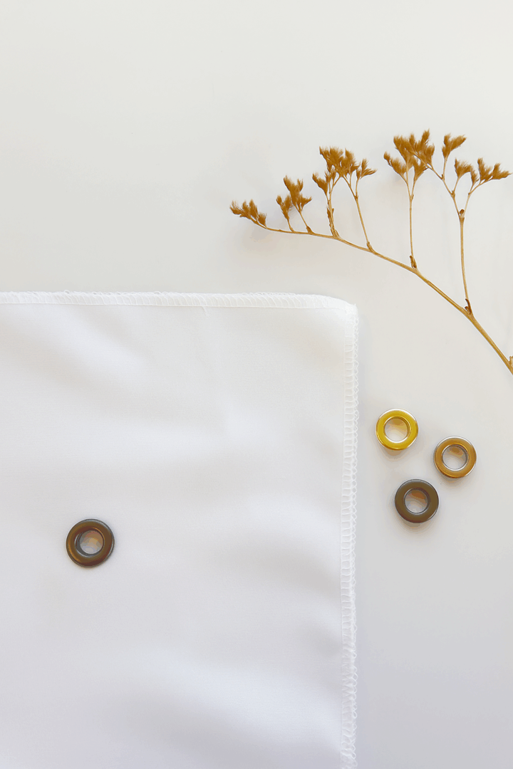 Gunmetal eyelet fabric sign material detail with brass grommets