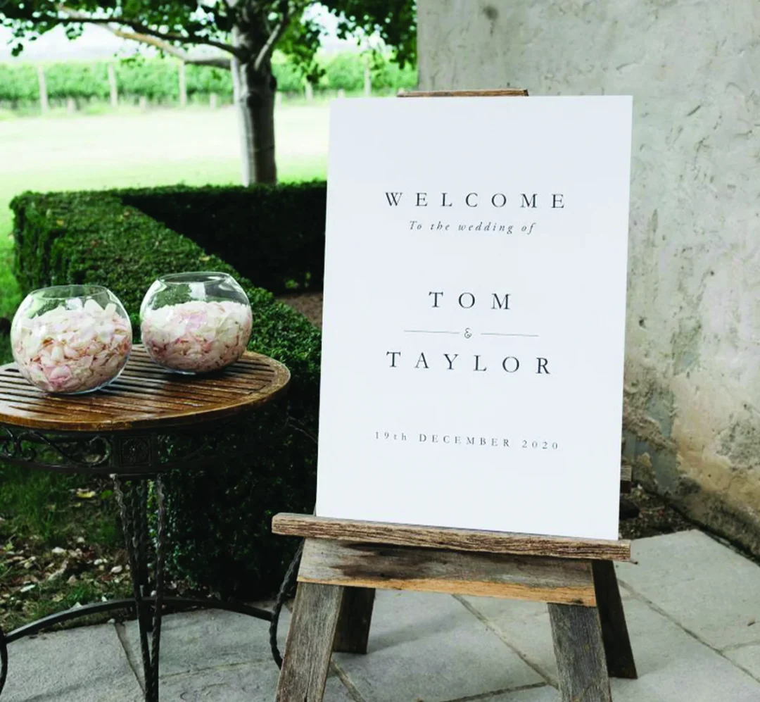 Wedding welcome sign on a wooden easel at a vineyard: classic welcome sign wording for elegant venues
