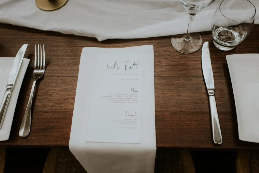 close-up of engraved aluminum keepsake box with wedding date and couple names, on a dark wood surface with dried flowers wedding stationery