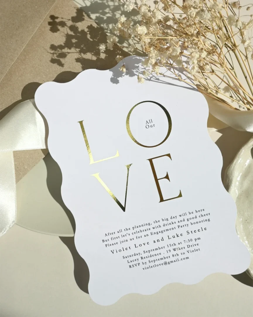 close-up of handwritten vow renewal invitation on thick textured cotton paper with gold foil lettering wedding stationery