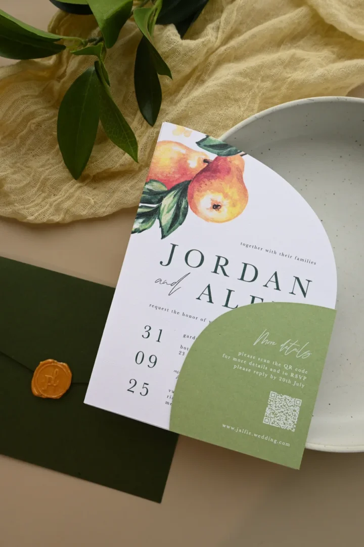 detail shot of a wedding envelope laid open showing a botanical watercolor liner with sage and dusty rose tones, photographed at an angle on a marble surface wedding stationery