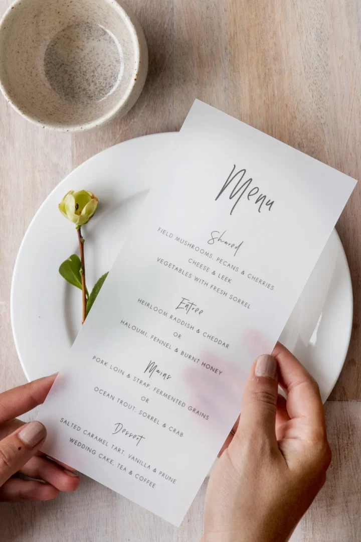 DIY wood-burning project in progress, hands holding a wood-burning pen over a cutting board with a wedding date design sketched in pencil, warm workshop lighting wedding stationery