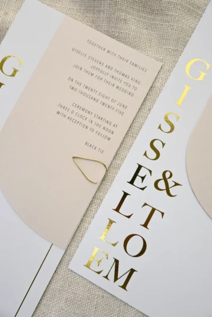 elegant vow renewal ceremony flat lay - invitation suite with floral details on linen texture, warm candlelight setting wedding stationery