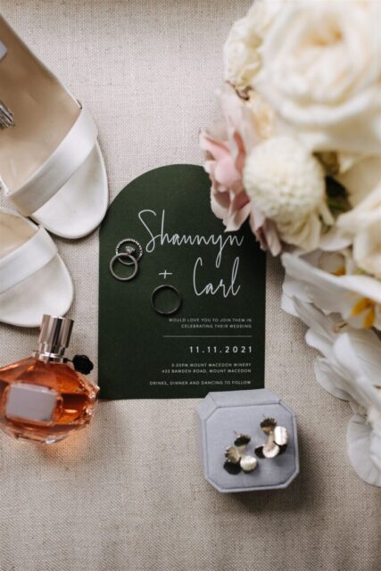 Dark green arch wedding invitation flatlay with eucalyptus