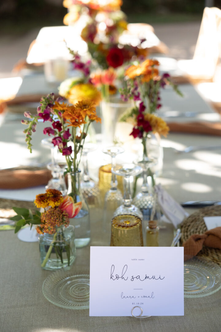 Wedding place card in gold wire holder with florals