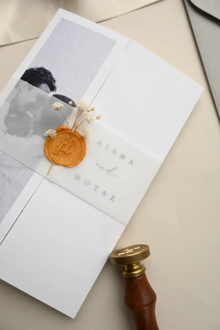 luxury letterpress wedding invitation with tactile debossed text and gold foil details on thick Wild Cotton paper, flat lay with wax seal stamp and fountain pen wedding stationery