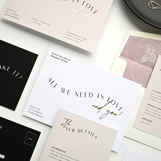 overhead flatlay of a pastel bridal shower invitation suite with a wrapped gift box, satin bow, champagne flutes, and scattered pink rose petals on a white marble surface wedding stationery