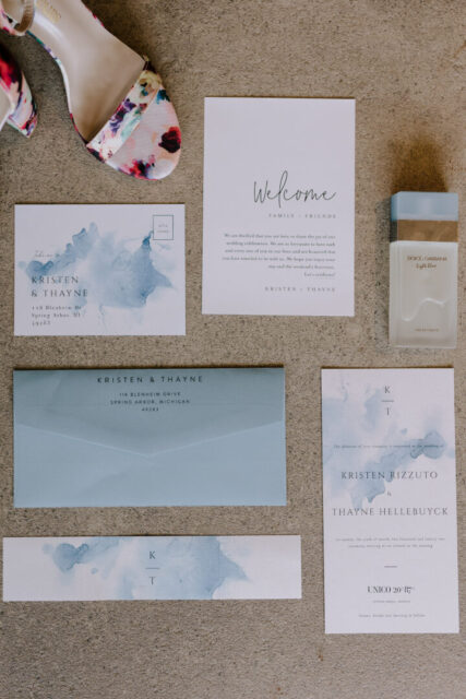 Wedding stationery suite flatlay with invitation and light blue envelope