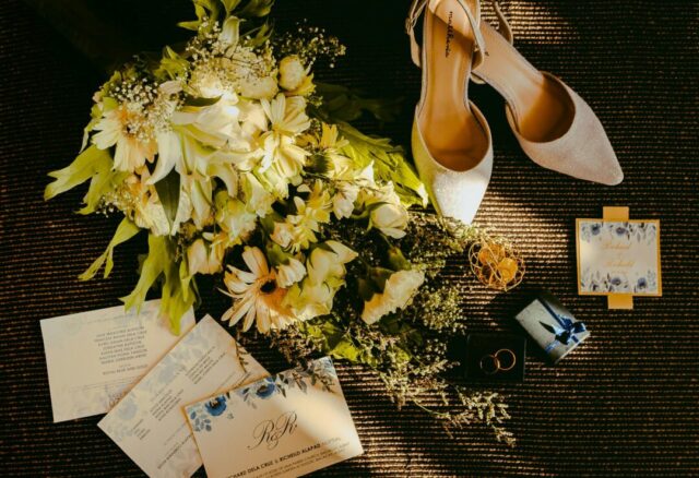 Elegant wedding stationery suite flat lay on marble surface showing invitation, RSVP card, and details card with calligraphy script and soft