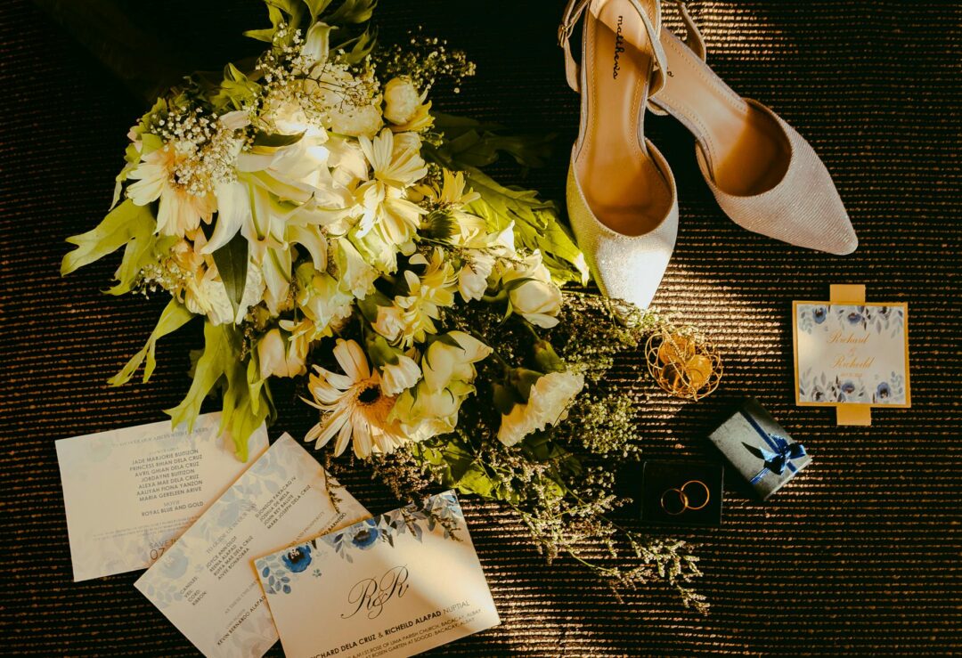 Elegant wedding stationery suite flat lay on marble surface showing invitation, RSVP card, and details card with calligraphy script and soft