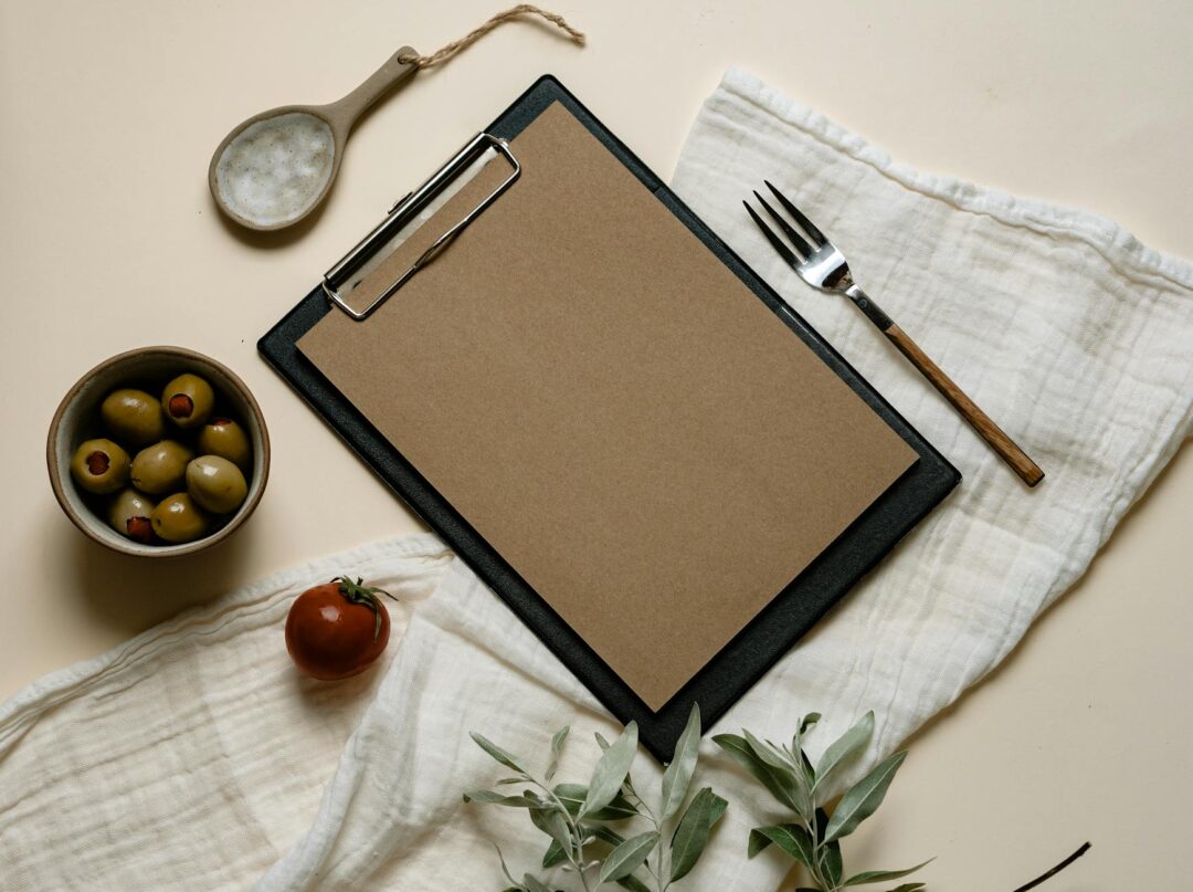 Paperlust invitation flatlay with warm terracotta and sage tones, styled with dried eucalyptus and a wax seal, overhead shot, Paperlust Driv