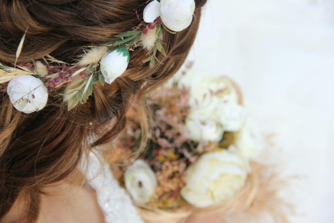 Close-up of a bride's half-up hairstyle secured with a delicate crystal hair vine threaded through loose waves, photographed from behind aga