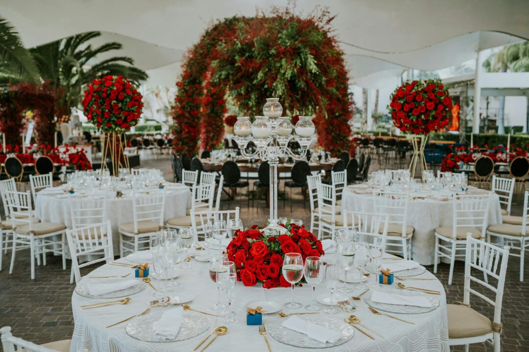 Wedding reception table with red and gold decorations, red envelopes beside each place setting, and elegant menu cards with Chinese calligraphy