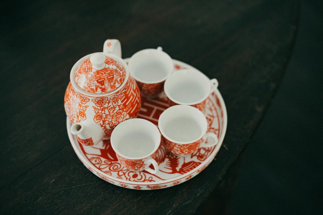Bride in red qun kwa serving tea at wedding ceremony