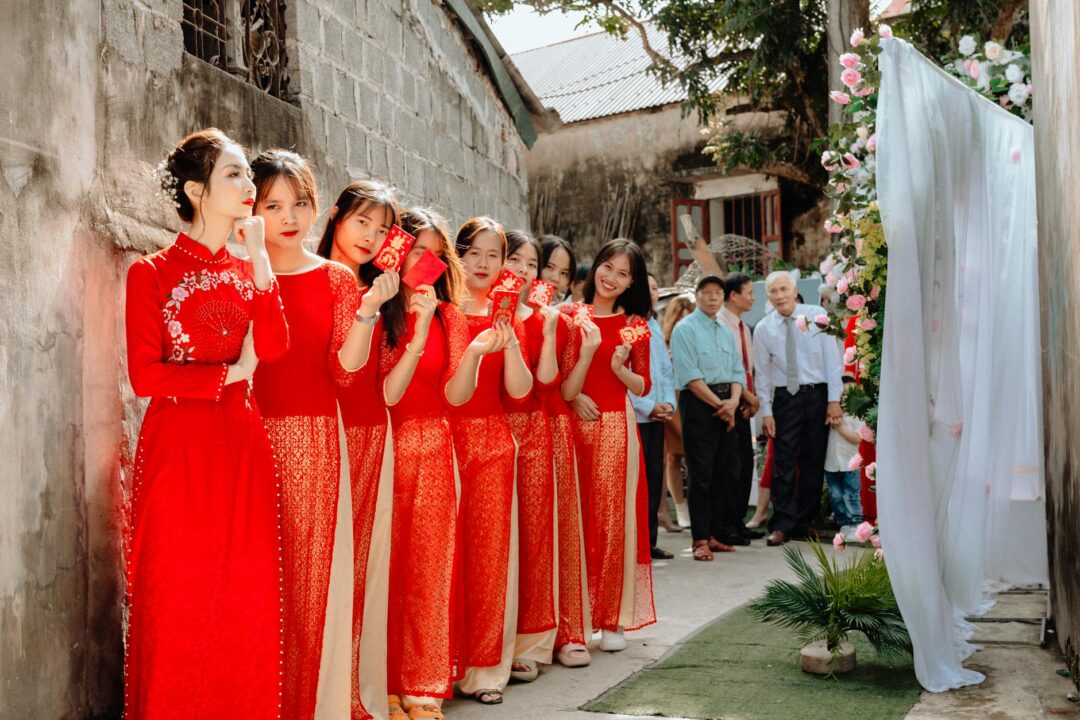 Groomsmen presenting red envelopes at the bride's door during chuangmen door games tradition