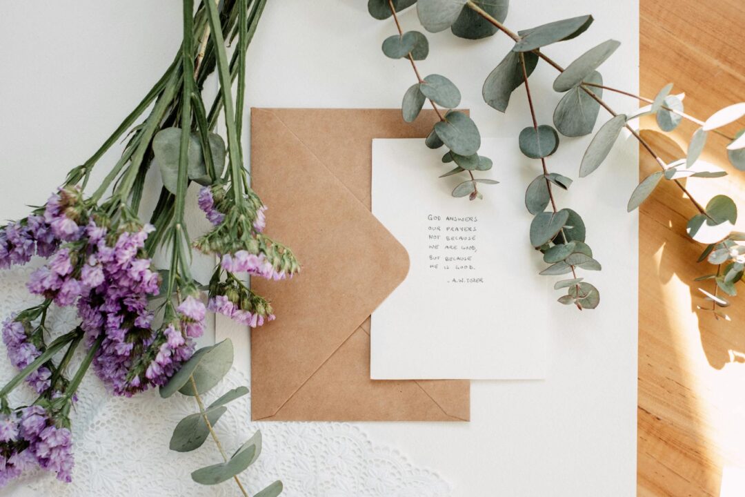 Paperlust arch-shaped wedding invitation with watercolor eucalyptus and botanical details, kraft envelope, dried pampas grass styling, earth