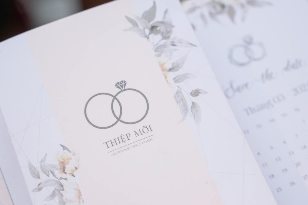 Minimalist botanical botanical wedding invitation with pressed wildflower design and calligraphy, styled flatly on a ceramic plate with gauz