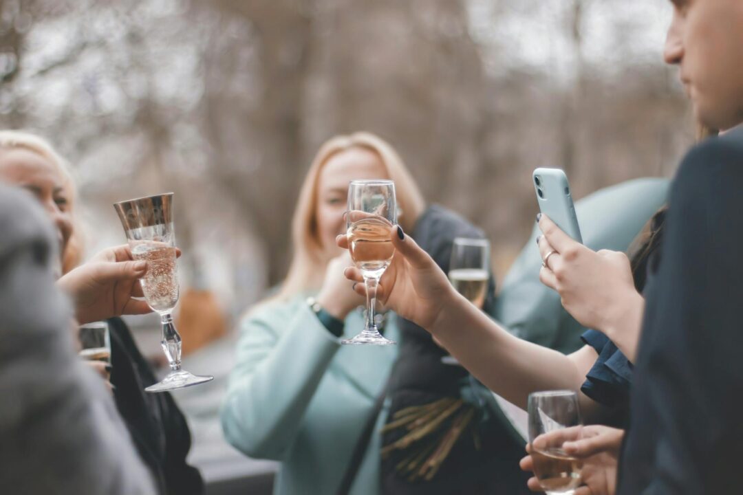Group of friends toasting with champagne glasses outdoors at an engagement celebration