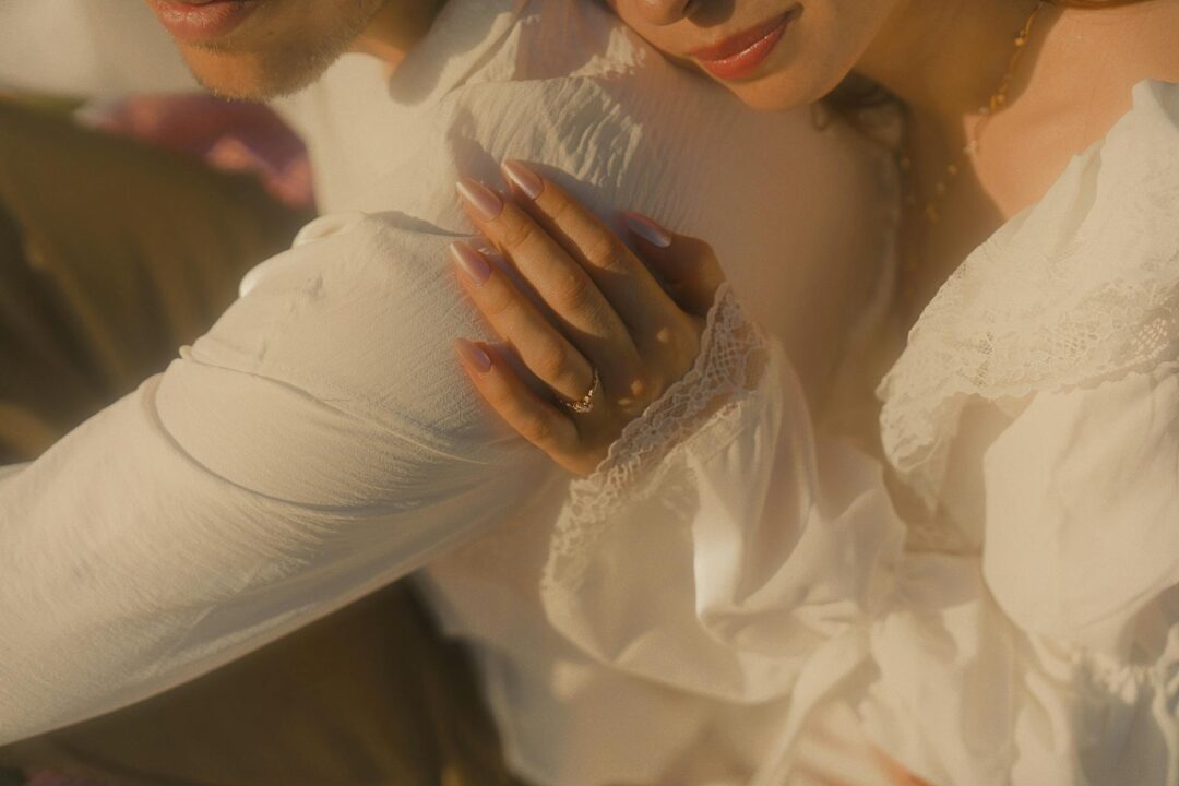 couple in editorial engagement portrait, warm golden hour, urban-meets-nature setting