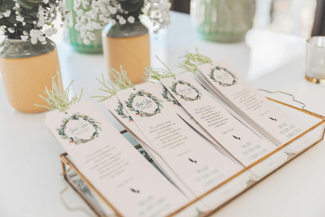 wedding programs stacked elegantly on a wooden table with flowers and ribbon detail in a rustic reception setting
