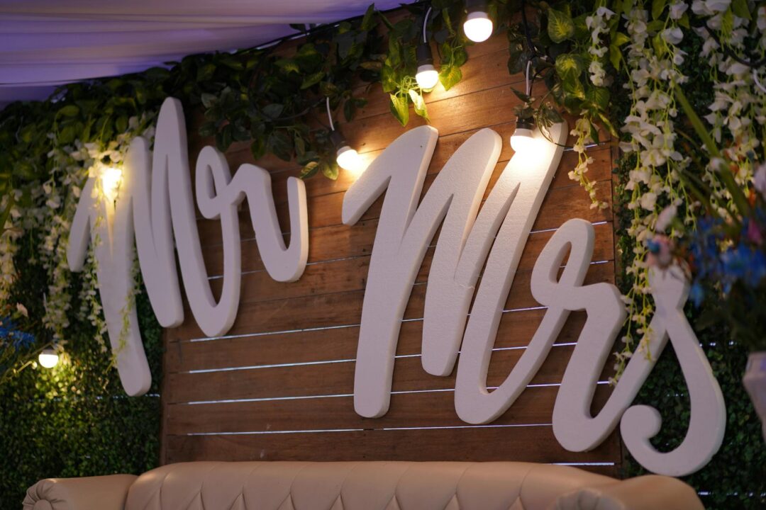 Mr and Mrs quiz game being played at a hens party dinner, women writing answers at a table with decorative flowers and glasses of champagne