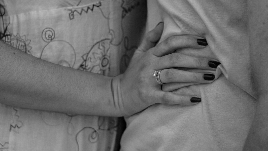 Couple's hands interlaced showing new wedding rings