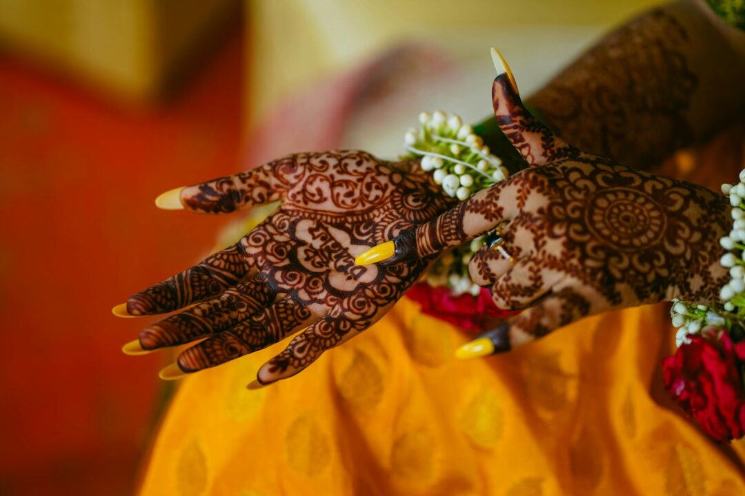Mehndi henna patterns on bride hands with gold bangles