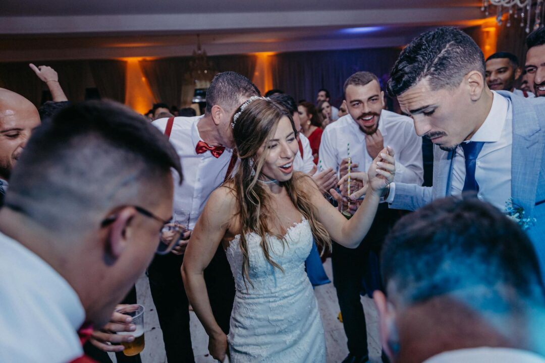 Bride and groom lifted in chairs during hora dance