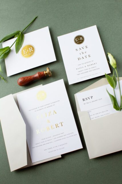 Paperlust classic monogram wedding invitation suite -- white invitation, save the date and RSVP cards with gold foil "E&R" monogram crest, sage green background, wax seal stamp tool styling