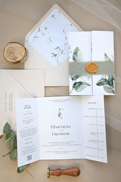 Paperlust Eden trifold wedding invitation with watercolour eucalyptus and sage botanicals, velvet belly band, and olive wax seal