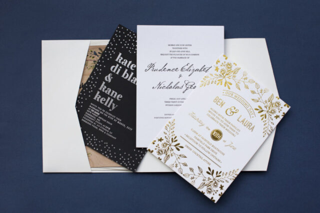 Paperlust navy and gold wedding invitation suite -- white invitation with gold foil botanical illustration and black confetti card on a navy blue background