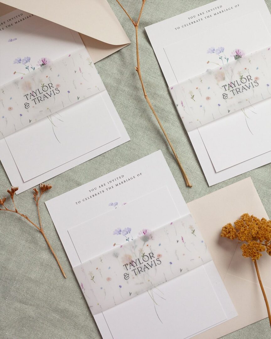 Paperlust Wildest Dreams wedding invitation with printed wildflower vellum belly band wrapped over the main card