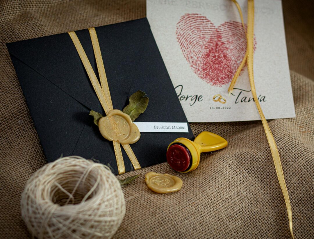 Paperlust wedding invitation suite with gold wax monogram seal on envelope flap showing detailed close up of wax seal pressed into cream col