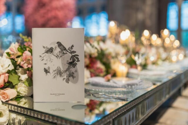 Elegant Paperlust wedding invitation suite flatlay - arch-shaped invitation with minimalist floral botanical illustration on soft white fabr