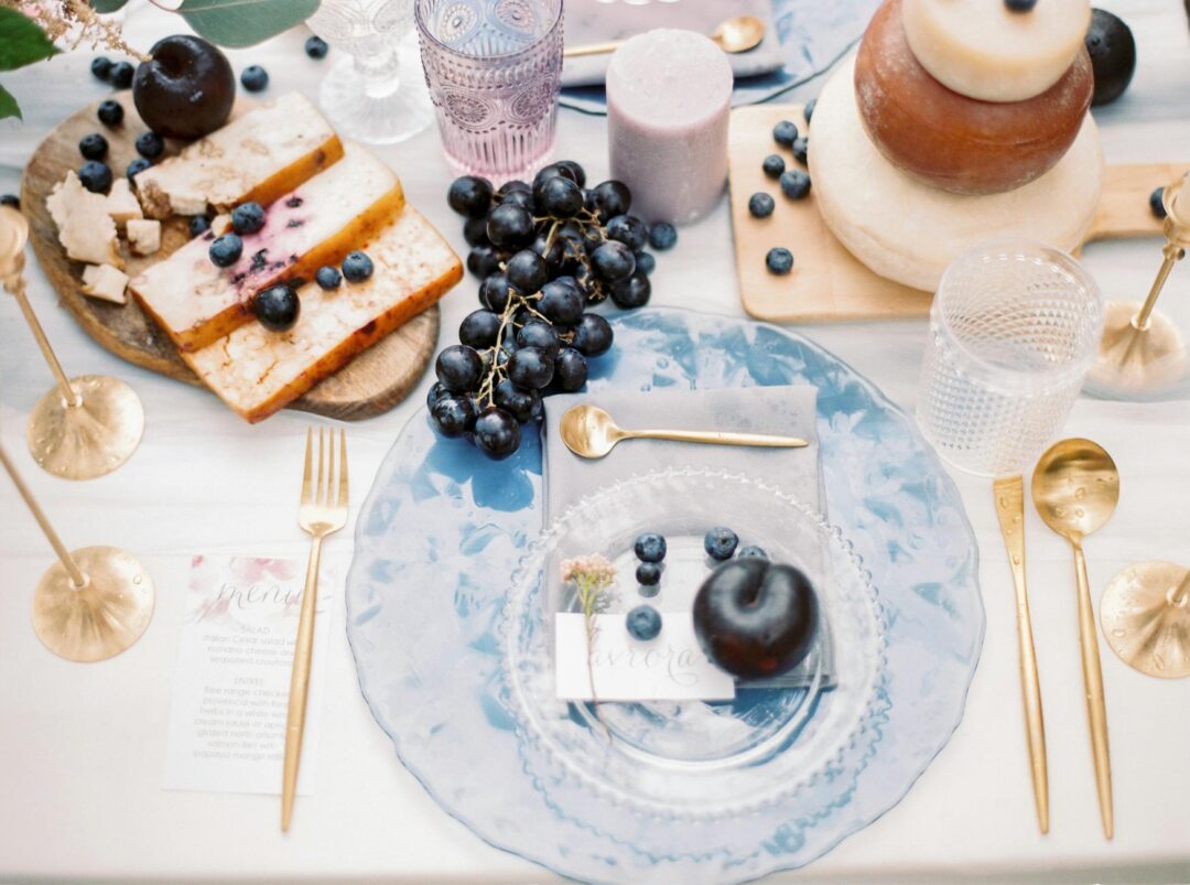 Wedding menu cards with cocktail hour items styled on a grazing table with small bites and floral accents