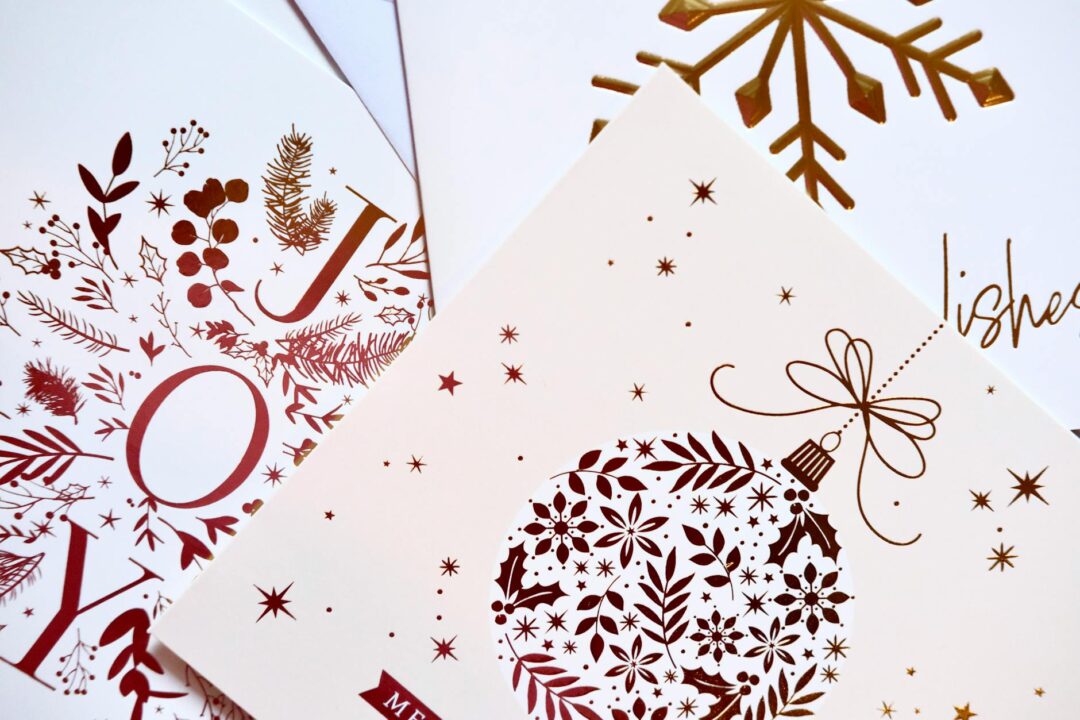 Paperlust Christmas 2022 holiday photo card with modern geometric design and cream envelope, styled flatlay with Merry Everything family pho