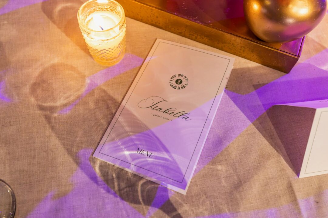 A Paperlust Sommer suite display showing a menu card, place card, and table number arranged on a neutral tablescape with earthy tones and or
