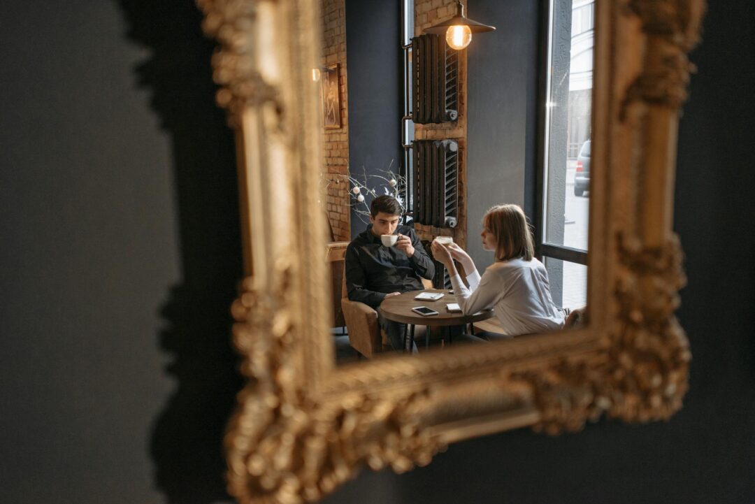 couple meeting with wedding photographer at coffee shop or studio, reviewing portfolio, candid and relaxed