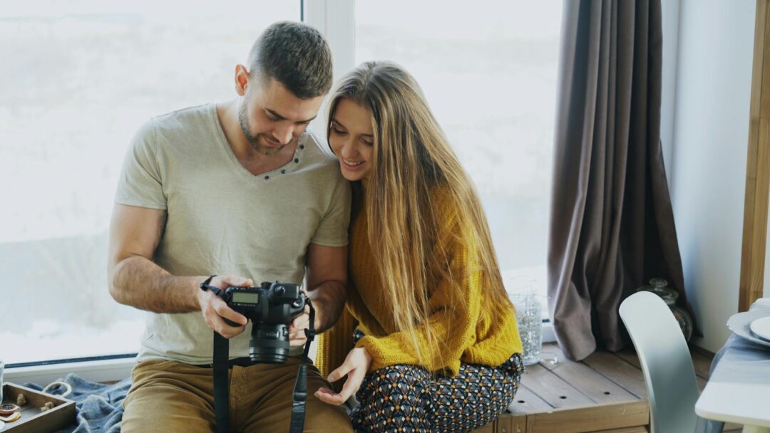 engaged couple reviewing photographer's portfolio book at a consultation meeting, warm natural light