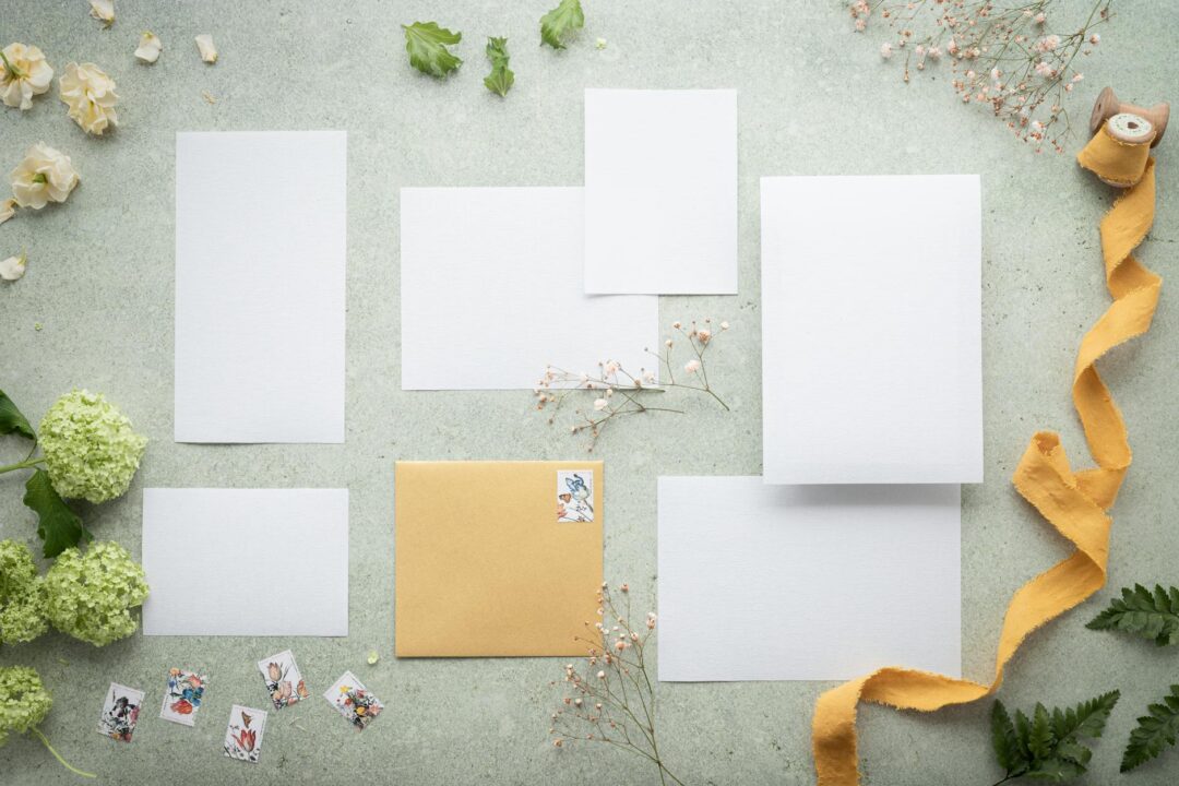wedding stationery flatlay with invitations, thank you cards, and envelopes on a linen surface, natural light overhead shot