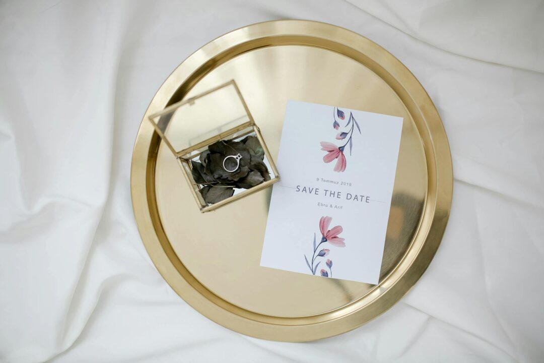 Paperlust Floweret or similar save-the-date flatlay showing a styled card with elegant botanical design on soft white or neutral fabric back