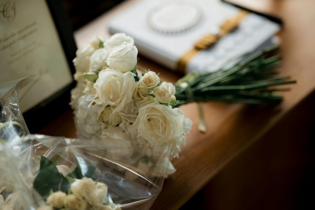 wedding florist arranging lush bridal bouquet of garden roses and eucalyptus in a bright studio